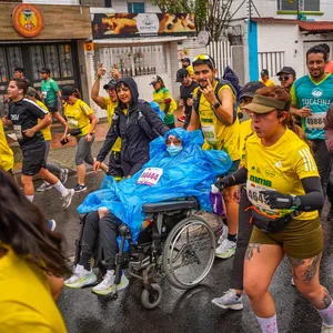 Atleta corriendo junto a un grupo de apoyo en la mmB