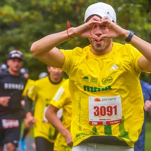 Participante haciendo un corazón y mirando a la cámara durante la carrera