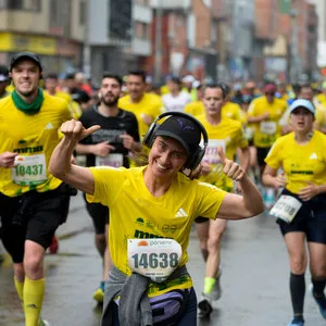 Mujer corriendo carrera en Bogotá con gran multitud