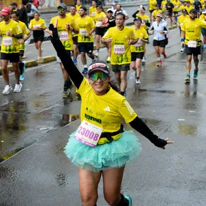 Mujer corriendo en tutu mientras levanta una mano