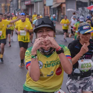 Corredora mostrando su entusiasmo mientras avanza en la carrera