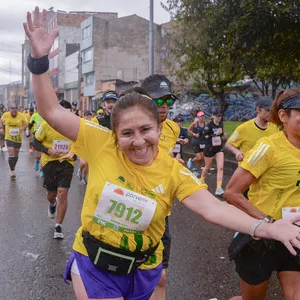 Mujer corriendo con energía y entusiasmo en el asfalto