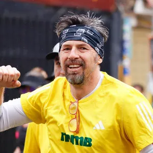 Corredor sonriente con la camiseta oficial de competencia