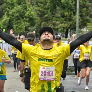 Atleta levantando los brazos en señal de triunfo al cruzar la meta