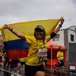 Atleta con bandera de colombia en carrera hoy bogota