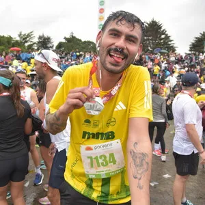 Hombre mostrando medallas de carreras atleticas