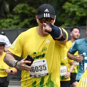 Atleta con tatuajes señalando a la cámara