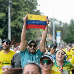 Hombre levantando con orgullo la bandera de Venezuela