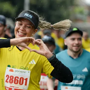 Mujer feliz corriendo 10K en la carrera