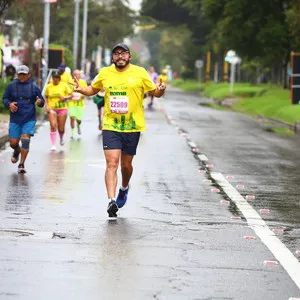 Hombre corriendo con alegría en la media maratón de Bogotá