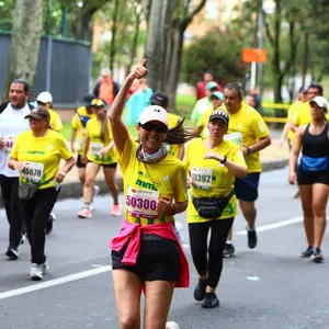 Atleta femenina celebrando con los brazos en alto en la carrera de maratón