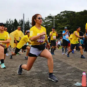 Corredores calentando con ejercicios de movilidad