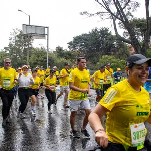 Grupo de atletas corriendo con calles mojadas en Bogotá