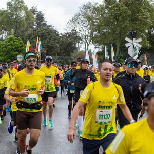 Hombre con canguro y visera Porvenir corriendo en las calles de Bogotá