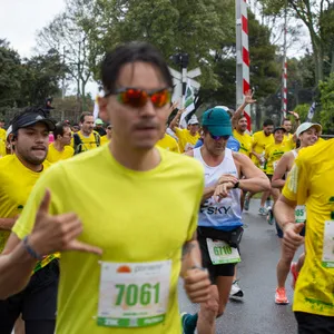 Hombre corriendo en la media maratón de Bogotá con gafas rojas