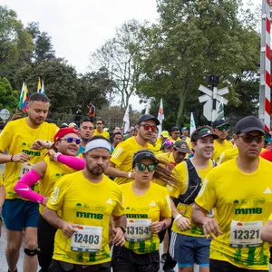 Grupo de amigos jóvenes corriendo en la media maratón de Bogotá