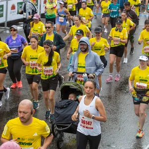 Hombre lleva coche junto con su bebé en la salida del recorrido de la media maratón de Bogotá