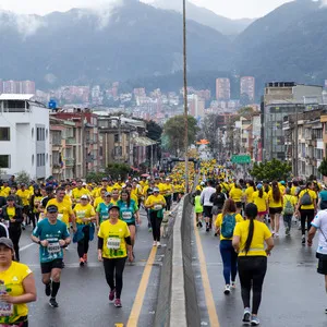 Mujer con gafas negras y una gorra corriendo llena de emoción