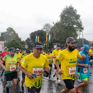 Personas corriendo en la lluvia con mirada de concentración