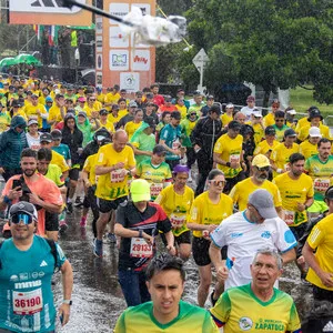 Personas corriendo por las calles de Bogotá en la salida de la media maratón de Bogotá