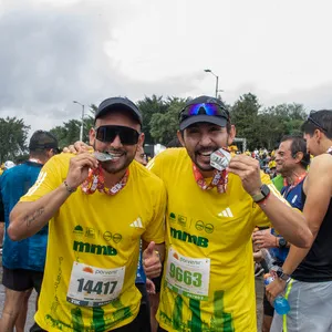 Dos hombres mordiendo medalla