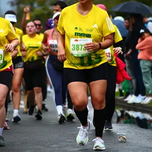 Mujer con gorra y gafas negras corre a meta