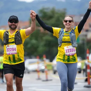 Pareja levanta las manos al estar próximos a llegar a la meta