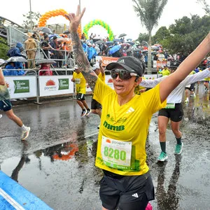 Bajo la lluvia mujer cruza la meta