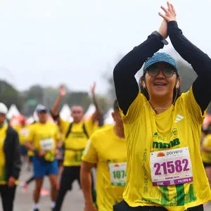 Atleta joven con los brazos arriba haciendo estiramiento antes de la carrera